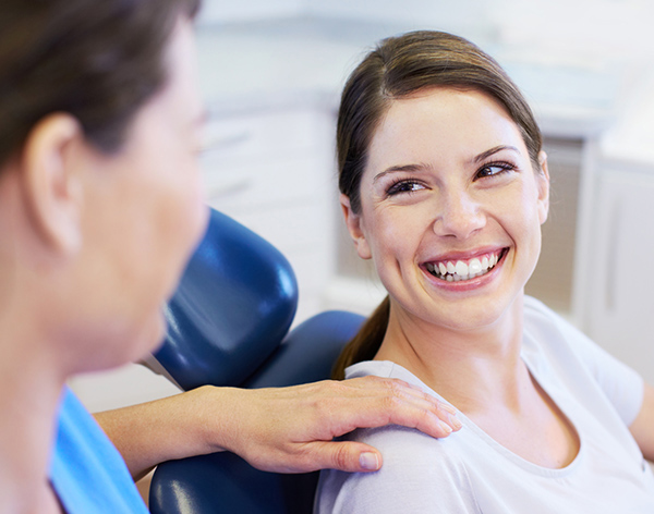 Woman receiving shoulder massage from therapist in clinical wellness setting.