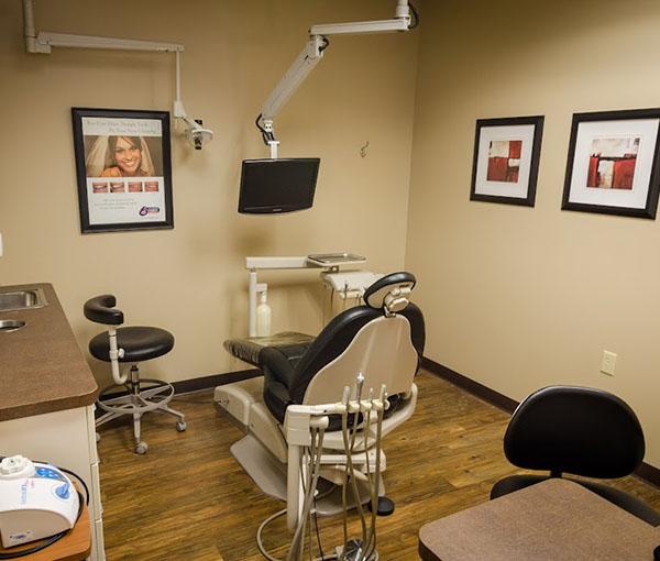 Modern dental operatory with chair, overhead light, and equipment in professional clinic setting.